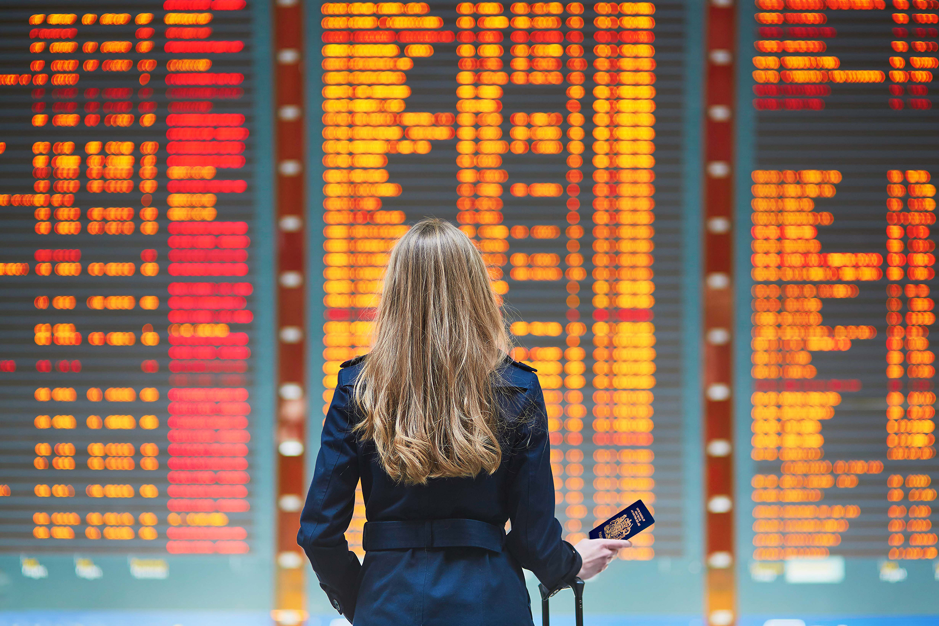 Image of woman looking at airport board