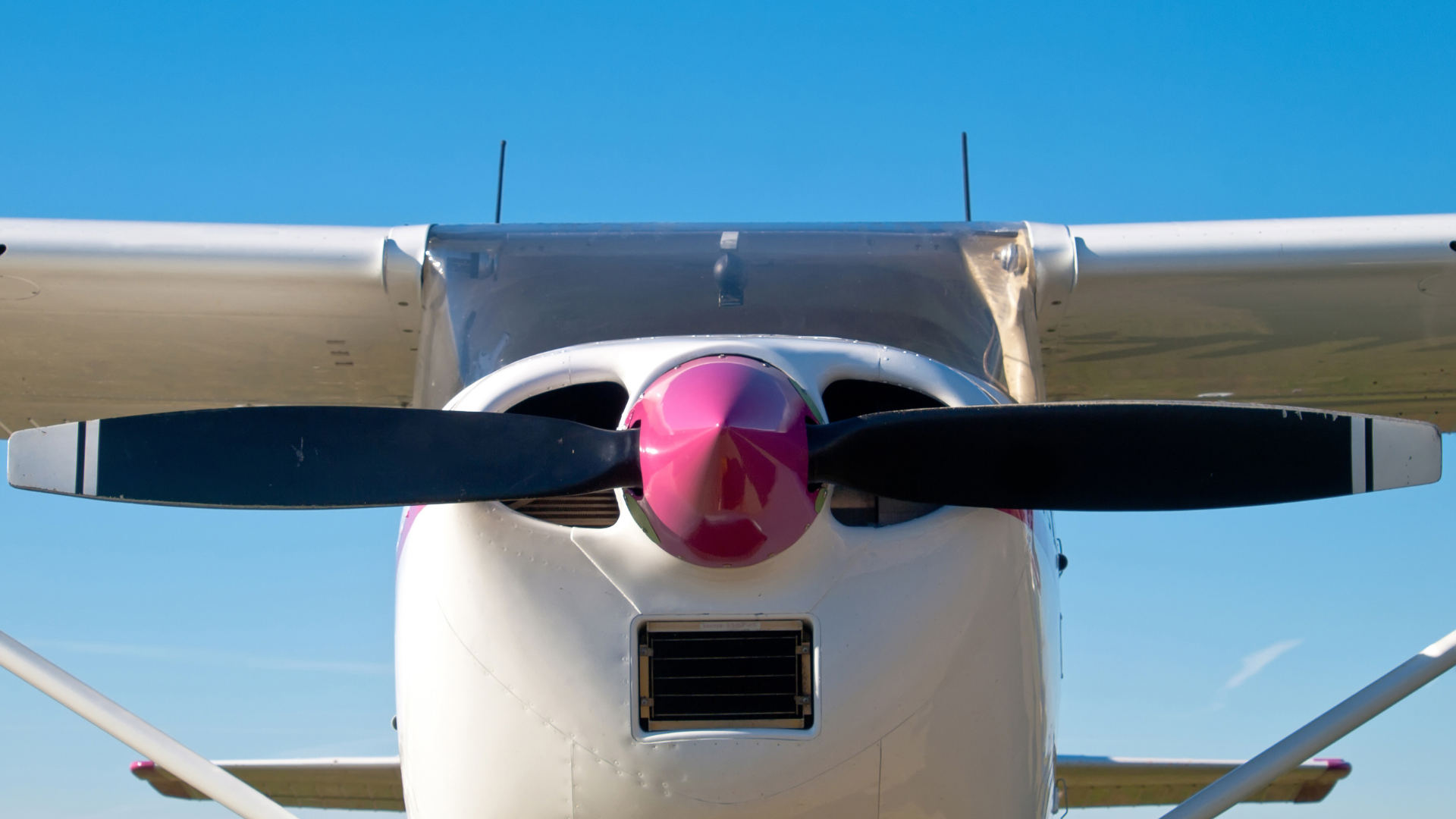 An image of a white coloured light aircraft stationary on the ground.